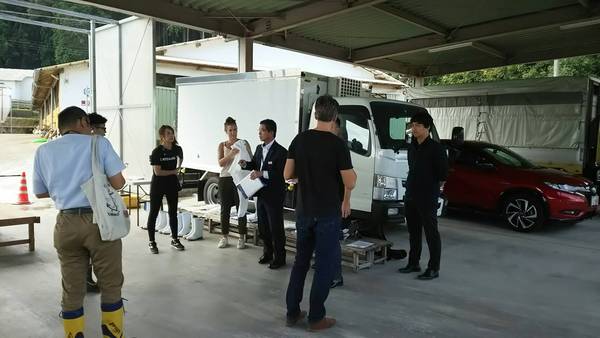 トラックの前で男性数名が話し合っている