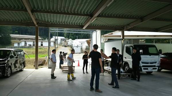 トラックの前で男性数名が話し合っている