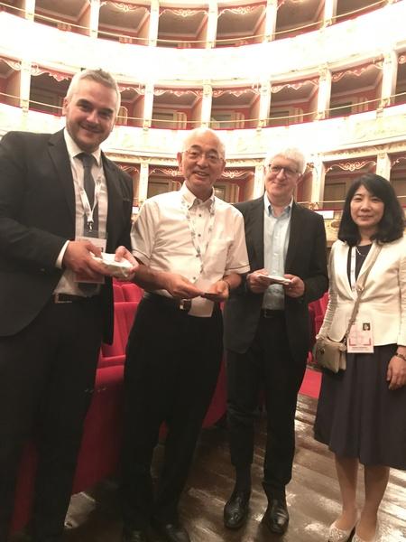 ファブリアーノ市長と市長フォーラム司会者が丹波焼を持って市長と小林秘書と一緒に記念撮影している写真