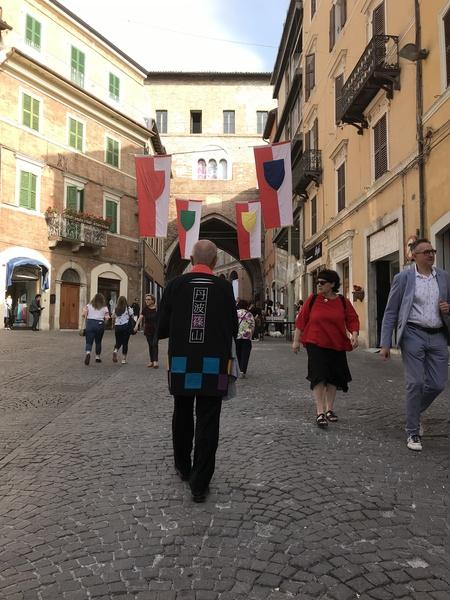 イタリアの街を歩いている後ろに丹波篠山とかかれた法被を着た市長を後ろから写した写真