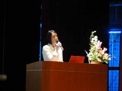 マイクを持つ加島 ゆう子さんの写真