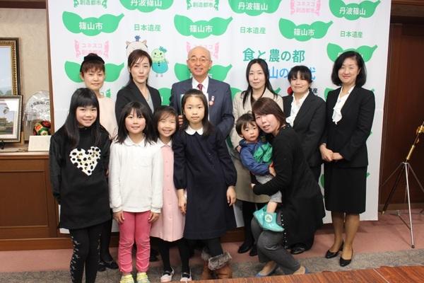 市長が女性委員会の方々とその子供達と一緒に写っている写真
