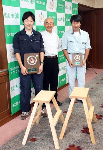 大工技術を競う「兵庫土建第23回青年技能競技大会」で受賞した園田さんと小林さんの二人が市長室に表敬訪問に来られて市長を挟んで記念撮影した写真