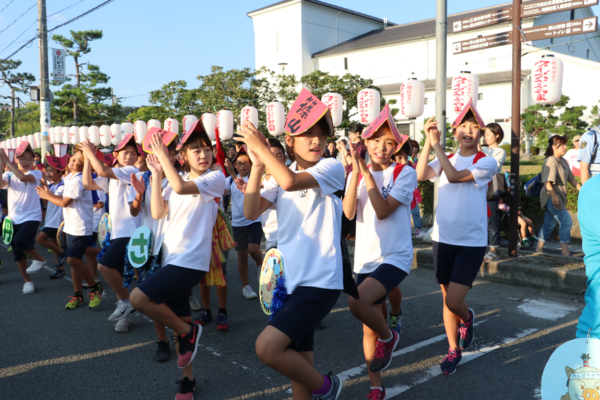 頭に篠山と書かれた手作りの帽子を被り子供達が道路で踊っている写真