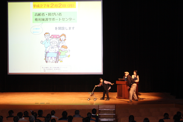 地域福祉課の発表で高齢者の役を男女で演じている写真