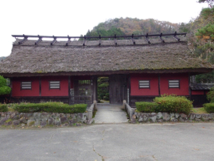 赤い壁が目を引く澤山家長屋門の外観写真