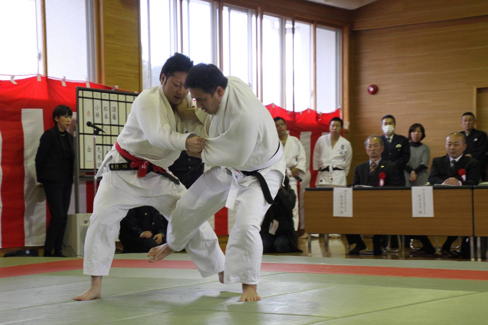 柔道の試合で、右足で相手の左足をひっかけようとしている写真