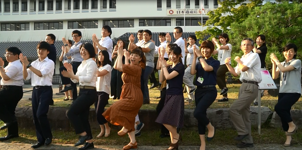 丹波篠山ふるさと大使の森田 まり子さんと、職員が手をあげて手をたたくポーズをしている集合写真
