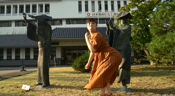 丹波篠山ふるさと大使の森田 まり子さんが、銅像の前で、おしりを突き出し、おさるの顔をしている写真