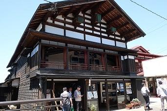 伝統的建造物の古い建物で、その中から人が出てきている写真
