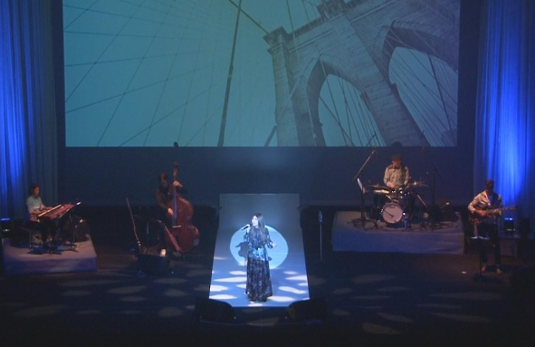 ライトアップされた舞台で、熱唱する遠山 恵さんの写真