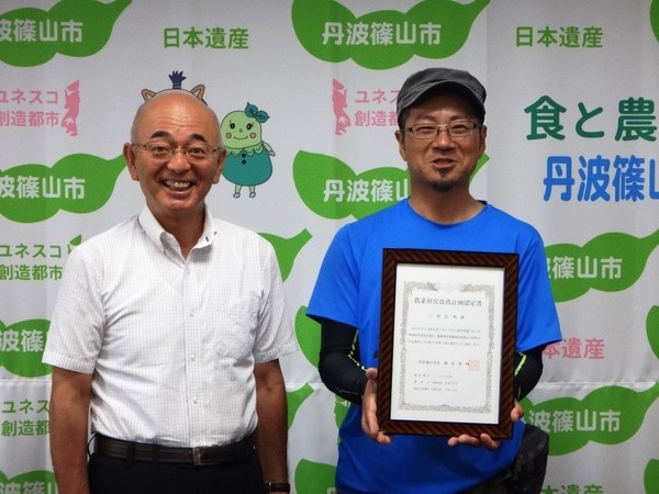 認定証を持った男性と市長との記念撮影