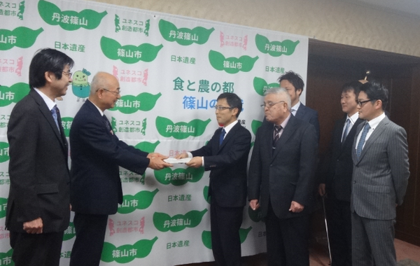 市長が田渕 真也会長ほか6名の方から「丹波篠山」の市名変更の要望書を手渡しで受け取っている様子の写真