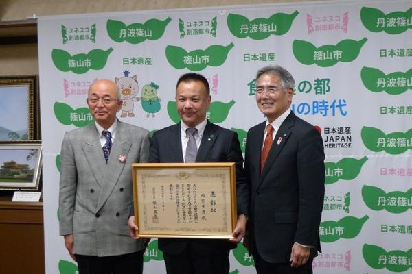 市長と関係者の方と表彰された西家 幸男さんの写真