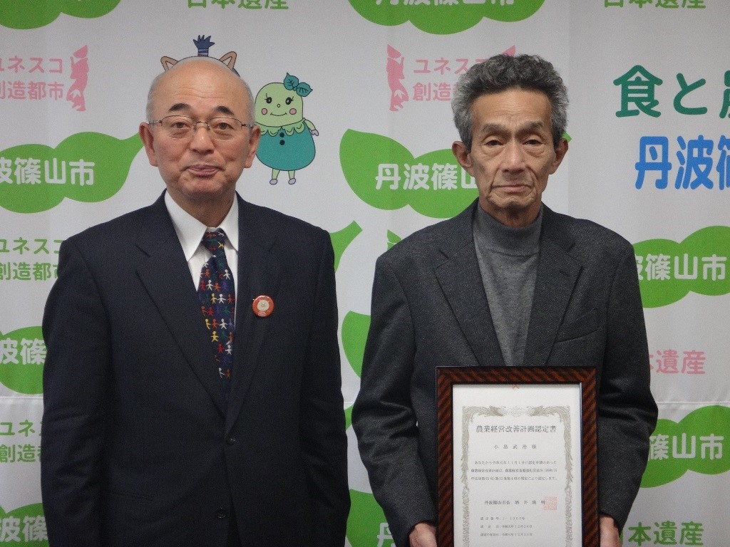 市役所の応接室にて、左が酒井市長、右が認定書を持った小島さん