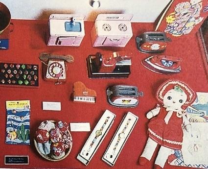 人形や電話・キッチン・アイロンなどのままごとセットやお手玉など女の子のおもちゃが展示してある写真
