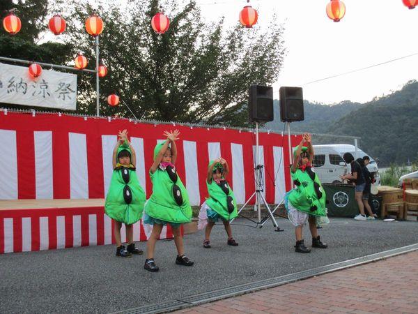 黒豆の緑色の衣装を着た子供4人が手を交差させて上にあげ踊っている写真