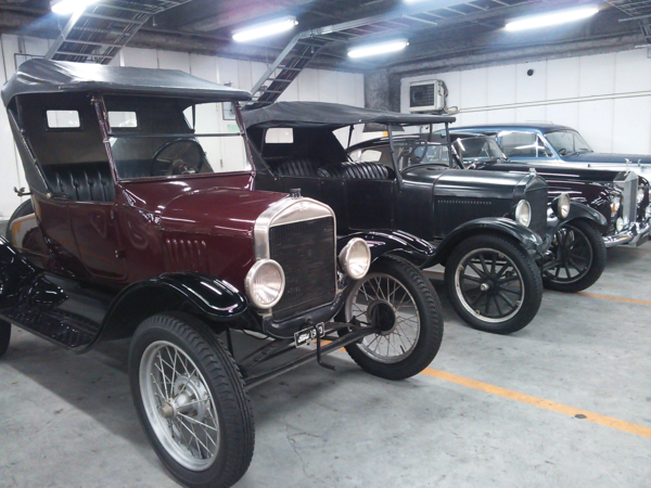 手前には2人乗りの背の高いクラシックカーが2台、奥には背の低いクラシックカーが2台停まっている写真