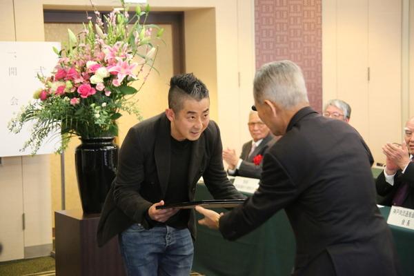 男性よ感謝状が渡され、お辞儀をしながら受け取る浜田 寿人さんの写真