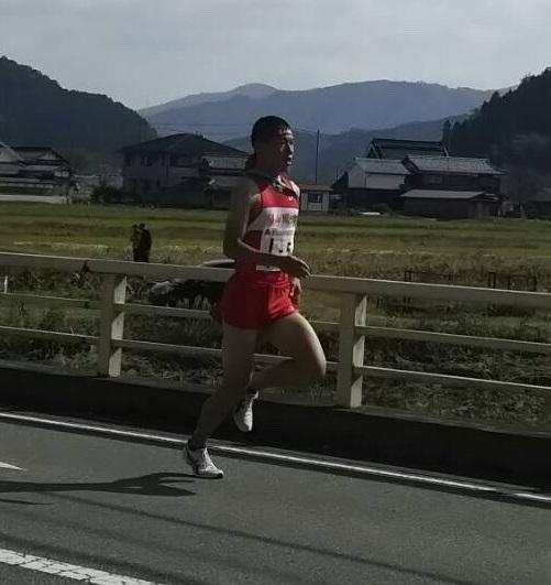 後方に田園が広がる橋の上を走っている三宅 大和選手の写真