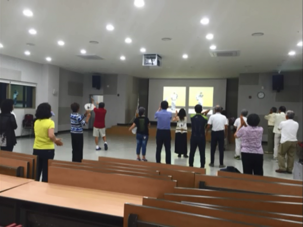 プロジェクターの映像を見ながら、デカンショ節を踊っている様子を後方から写している写真