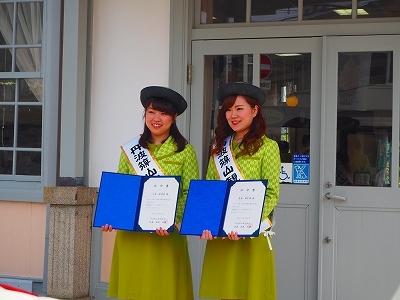 土井 絵理菜さんと尾嶋 珠里希さんが観光大使の制服に帽子をかぶり記念写真