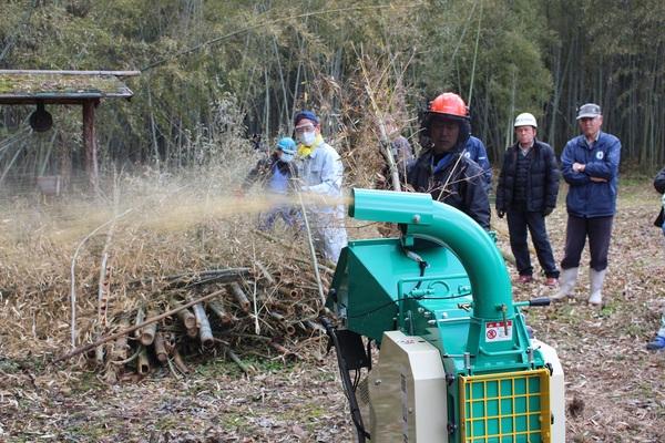 地域や団体の方が放置竹林で竹粉砕機を使い竹を粉砕している写真