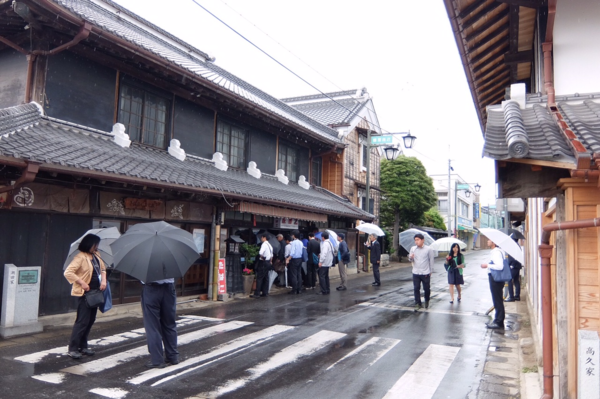 雨の日に傘を差し、丹波篠山の城下町を歩いている人達の写真