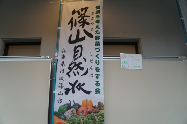 市長が筆で書いた「篠山自然派」の文字と野菜の写真が載ったのぼり旗の写真