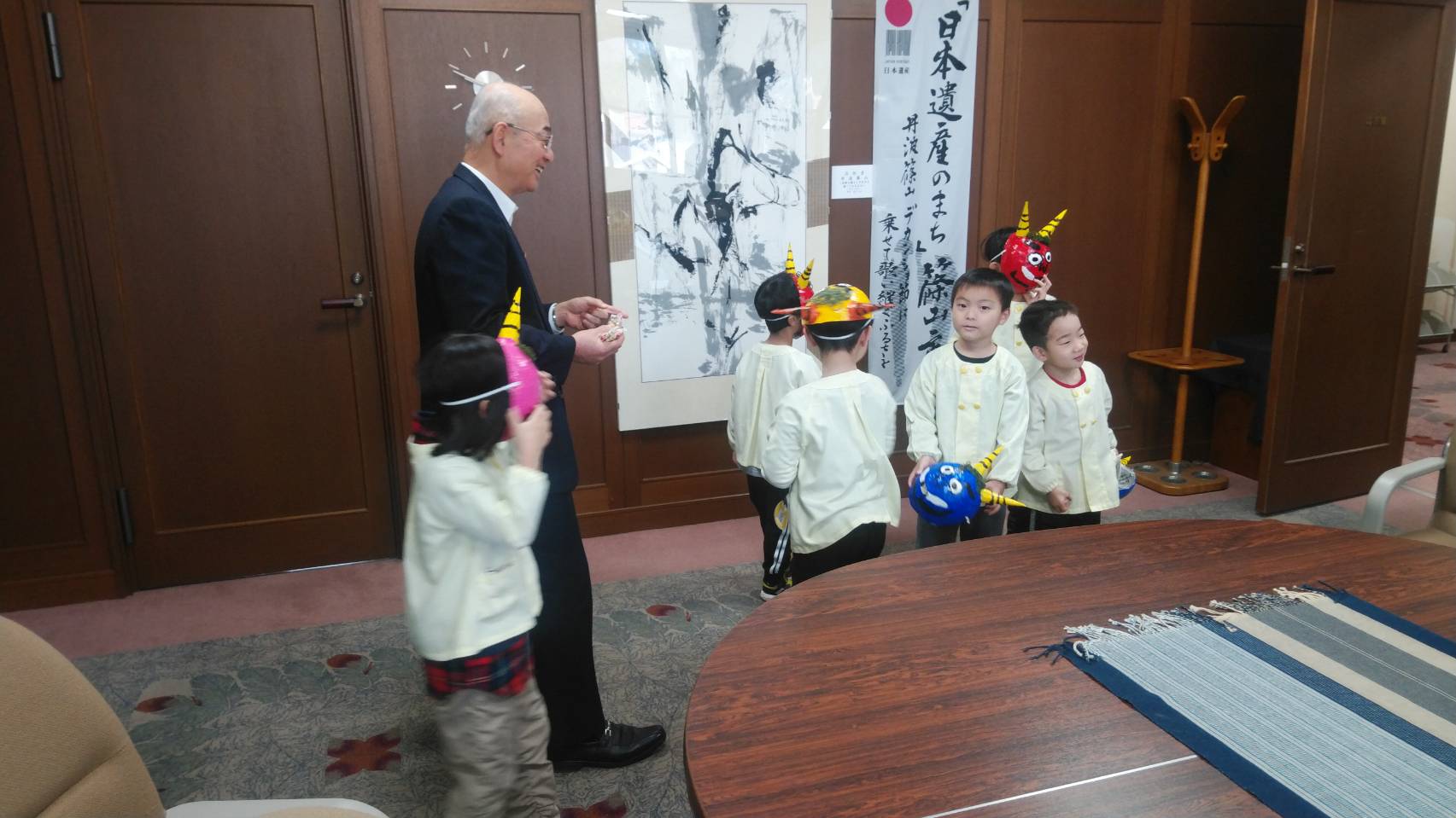 お面を持った子どもたちと、酒井市長が話している写真