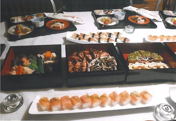 寿司、煮つけや和食の詰まったお重のパーティー料理の写真