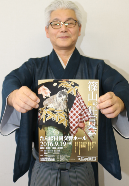 山口 耕道さんが「篠山秋の狂言会」のチラシを手に持っている写真