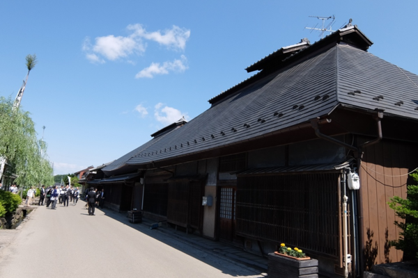 壁が茶色で屋根が黒色の大きな日本家屋の写真