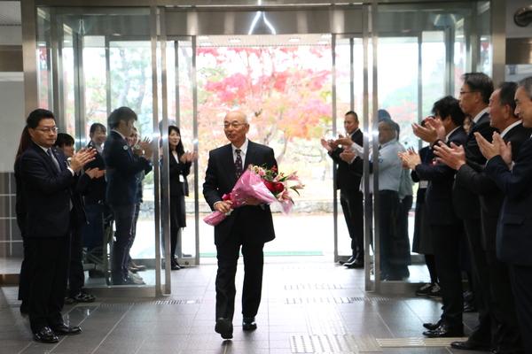 市長が花束を持って、多くの方に拍手されている写真
