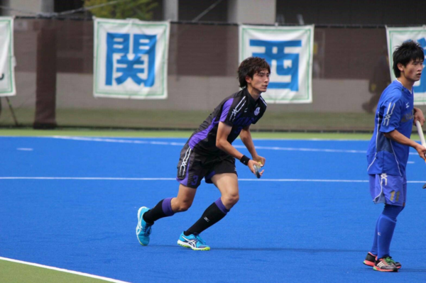 黒のユニフォーム姿の稲山選手がスティックを持ち練習している写真