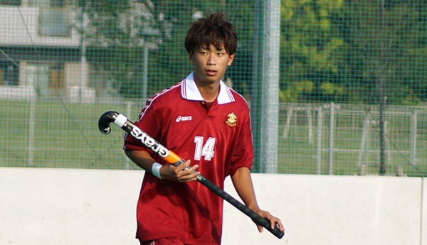 赤のユニフォーム姿の森下選手がスティックを持っている写真