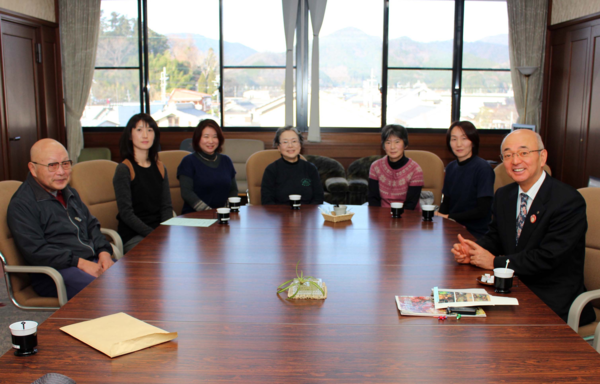 テーブルの周りに座っている中野母親クラブの皆さんと市長らの記念写真