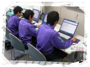 体操服を着た三人の学生がパソコンに向かって作業している