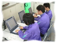 体操服を着た三人の学生がパソコンを用いて作業している。