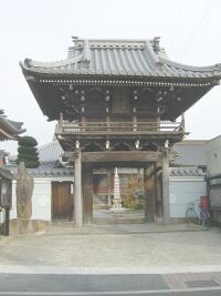 お寺の門を真正面から撮った写真。奥にお寺が見える。