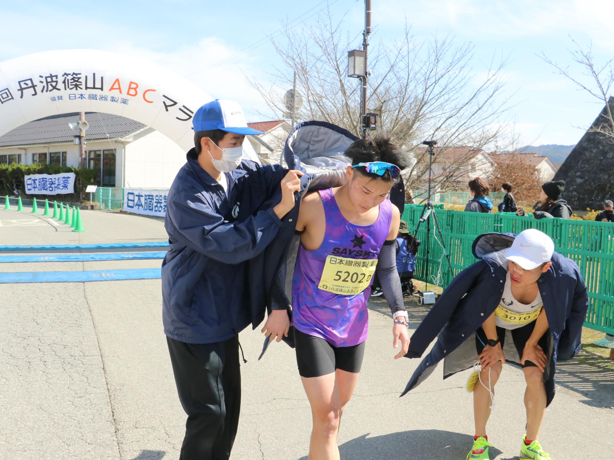 選手に上着をかけるスタッフ