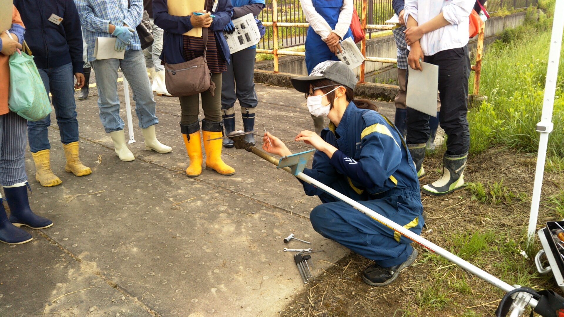 草刈り機の取り扱い説明を聞く受講者