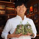 黒枝豆を手に取り笑顔の大坂宇津実さんの写真
